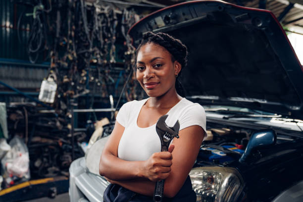 Portrait of woman auto mechanic working at car repair shop with looking at camera.